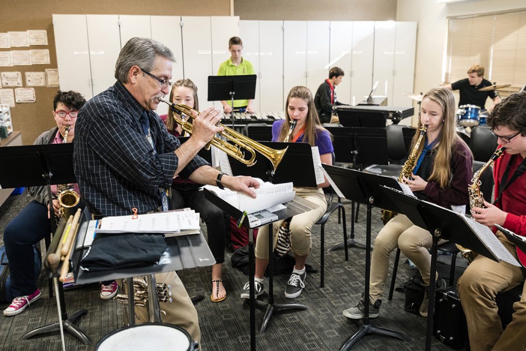 professor tocando trompete na aula de música.