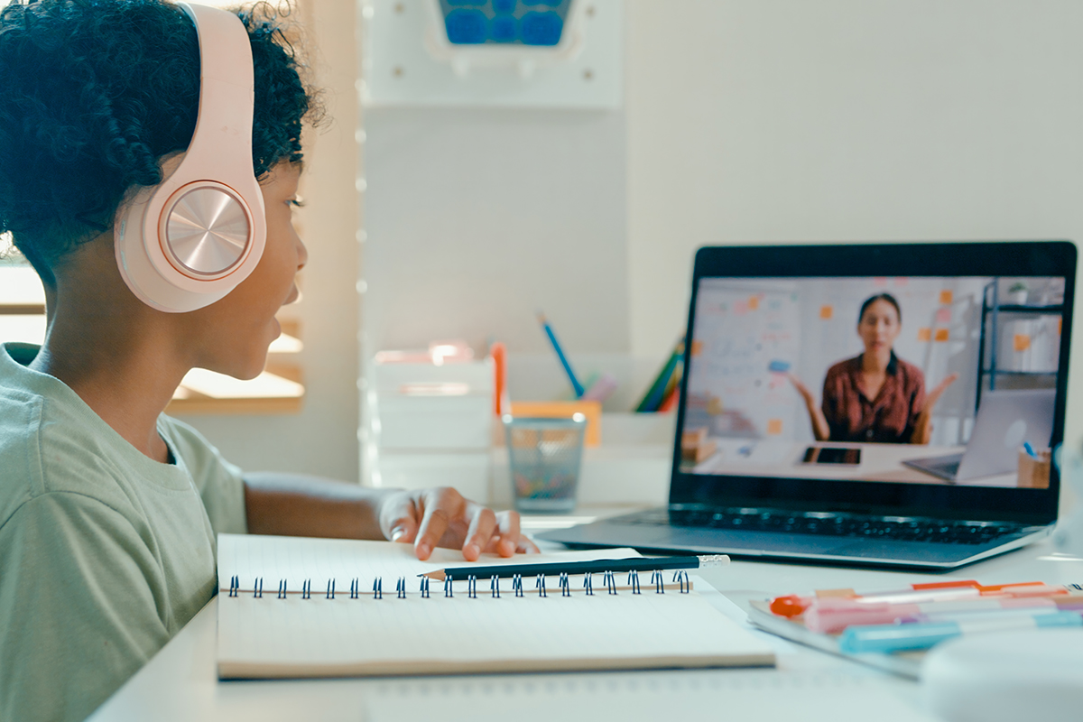 jovem-africano-americano-menino-ouve-o-professor-durante-sessão-de-aprendizagem-remota-demonstrando-engajamento-através-da-tecnologia-em-casa-de-cursos-de-educação-online-